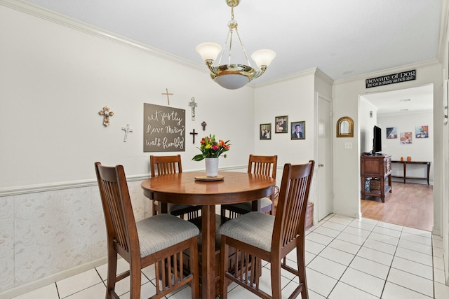 dining room featuring light tile patterned floors, crown molding, and a notable chandelier