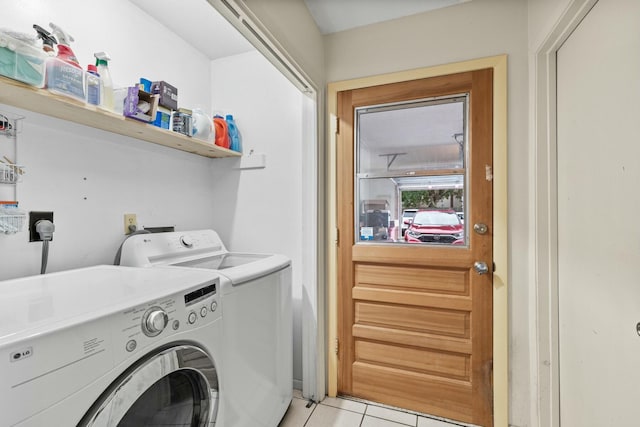 laundry area featuring washing machine and clothes dryer and light tile patterned floors