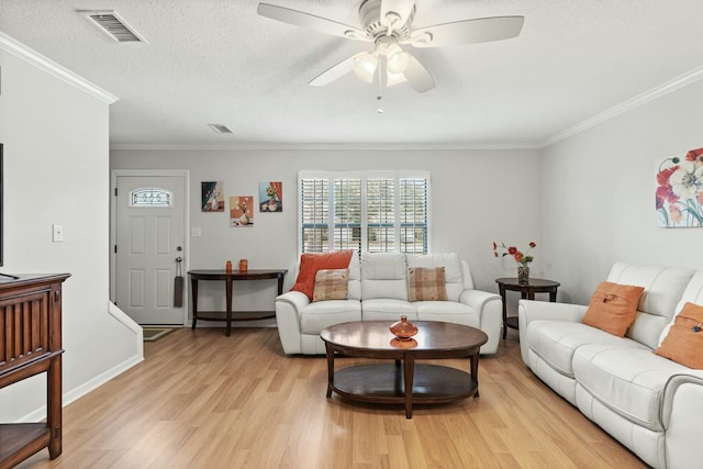 living room with ceiling fan, light hardwood / wood-style flooring, ornamental molding, and a textured ceiling