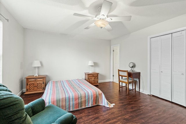 bedroom with dark wood-type flooring, ceiling fan, and a closet