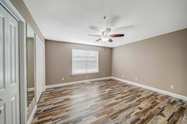 unfurnished bedroom with ceiling fan and wood-type flooring