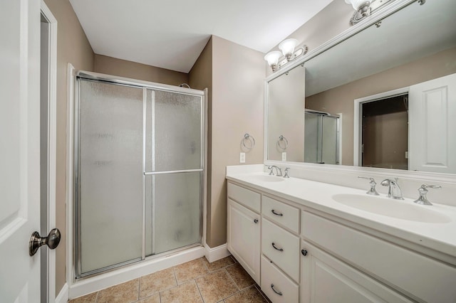 bathroom with an enclosed shower, vanity, and tile patterned flooring