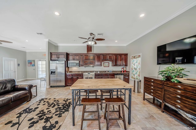 kitchen featuring ornamental molding, appliances with stainless steel finishes, and ceiling fan