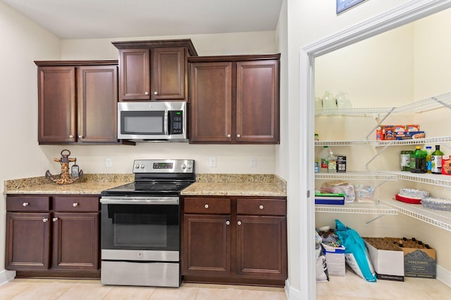 1729 Waterford Sound Blvd, Gulf Breeze, FL 32563 - kitchen with light stone counters, stainless steel appliances, and light tile patterned flooring