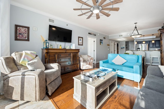 living room with crown molding, ceiling fan, and wood-type flooring