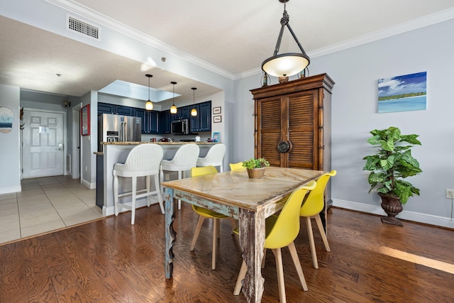 dining area with crown molding and wood-type flooring