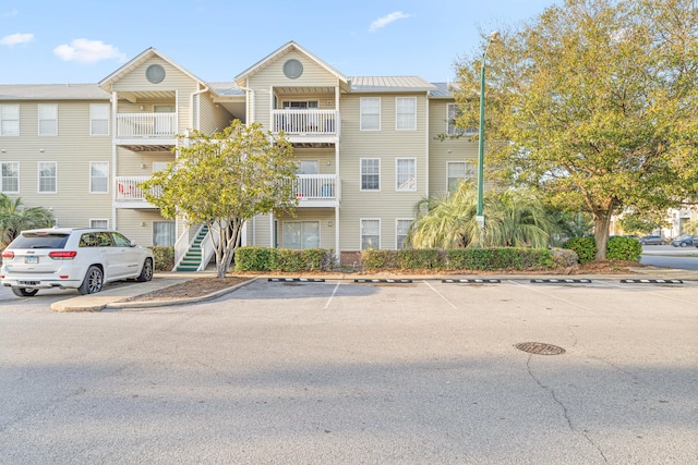 view of property featuring uncovered parking and stairway