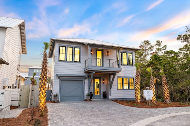 view of front of property featuring a balcony and a garage