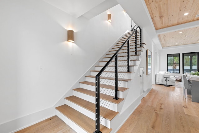 staircase with hardwood / wood-style floors and wooden ceiling