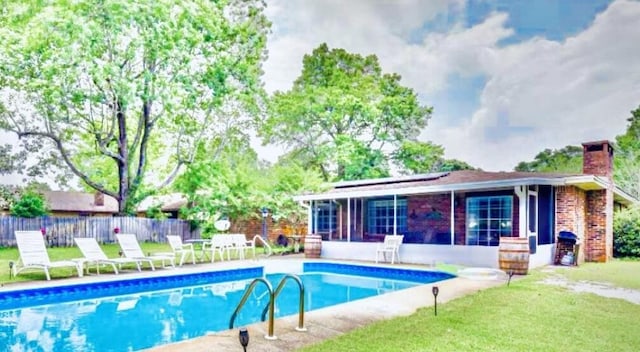 view of pool with a lawn