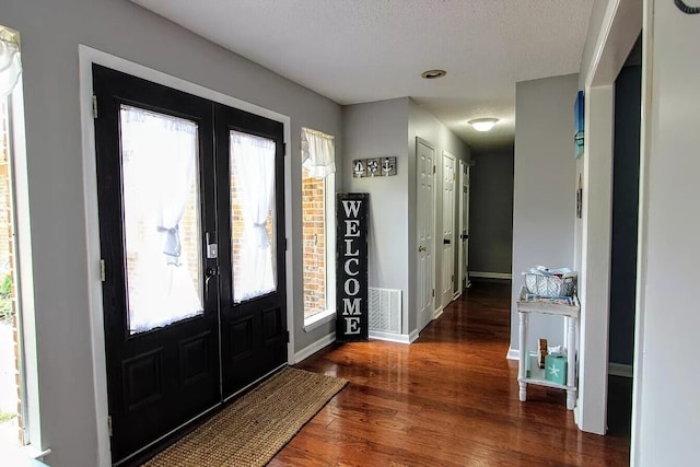 entryway featuring dark hardwood / wood-style floors, a textured ceiling, and french doors