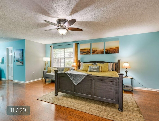 bedroom featuring ceiling fan, wood-type flooring, and a textured ceiling