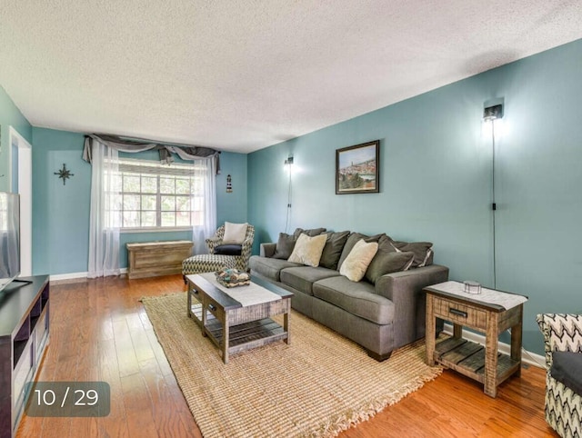 living room with wood-type flooring and a textured ceiling