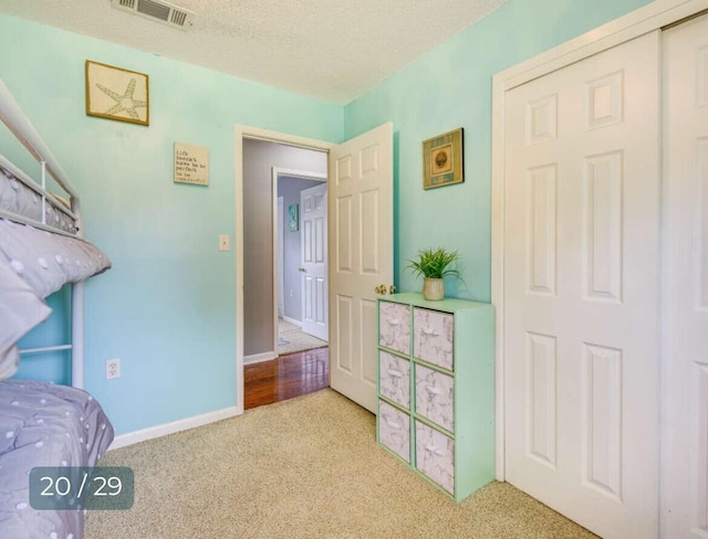 bedroom featuring light colored carpet and a textured ceiling