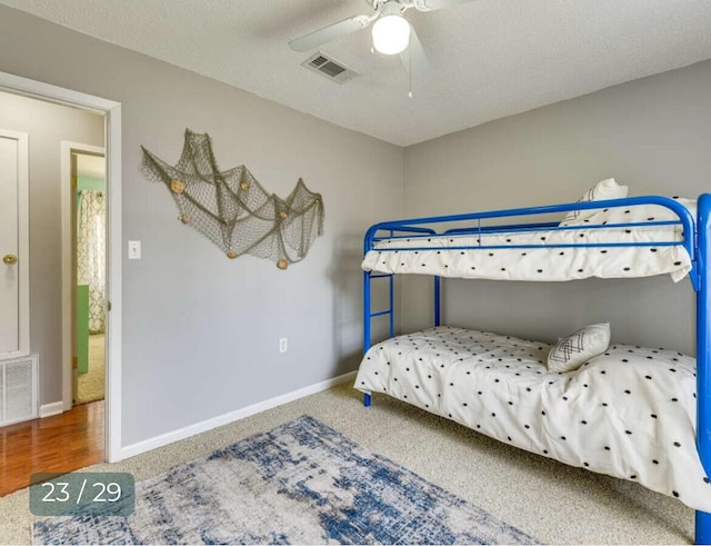 bedroom with ceiling fan, carpet, and a textured ceiling