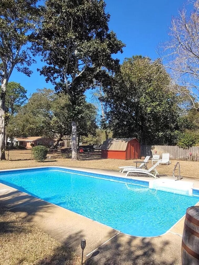 view of swimming pool featuring a storage shed