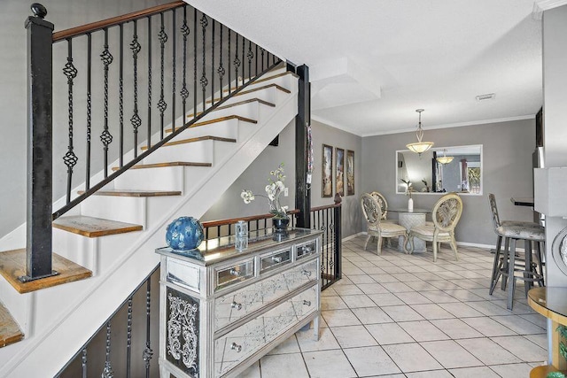 stairs with crown molding and tile patterned floors