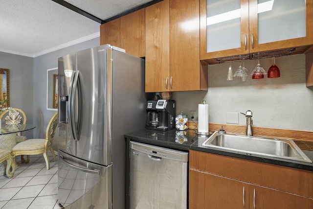 kitchen with light tile patterned flooring, sink, a textured ceiling, ornamental molding, and stainless steel appliances