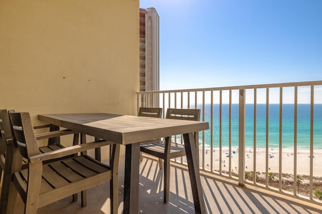 balcony featuring a view of the beach and a water view