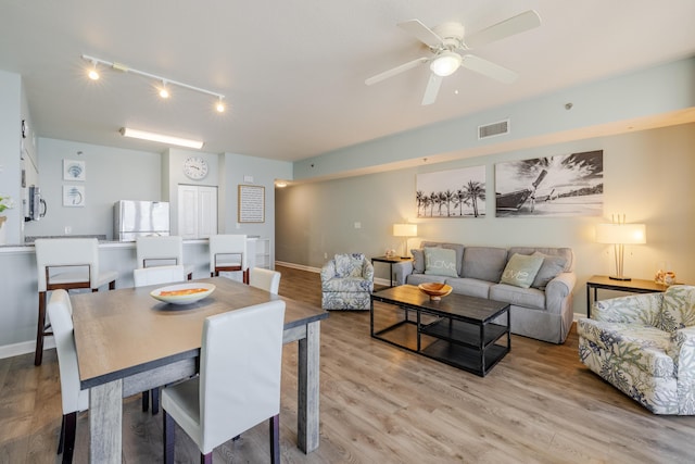 dining area with ceiling fan and light hardwood / wood-style flooring