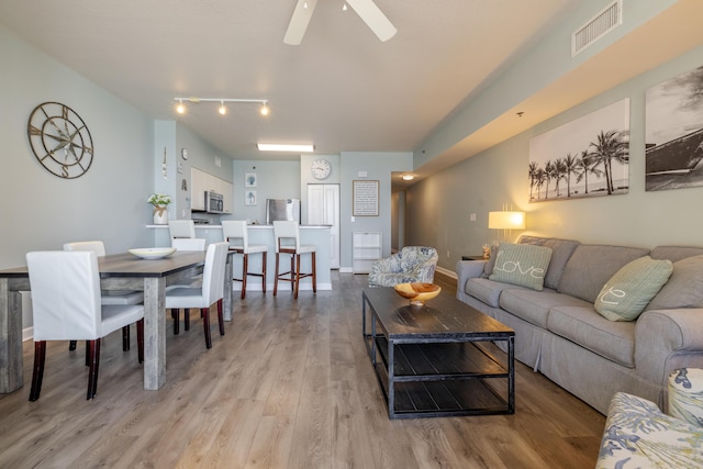 living room featuring ceiling fan and light wood-type flooring