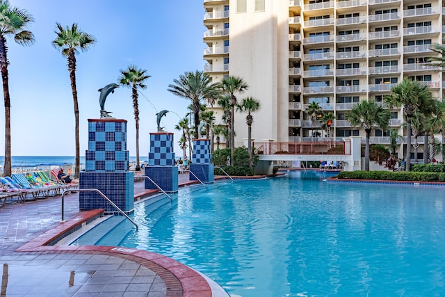 view of pool with pool water feature and a water view