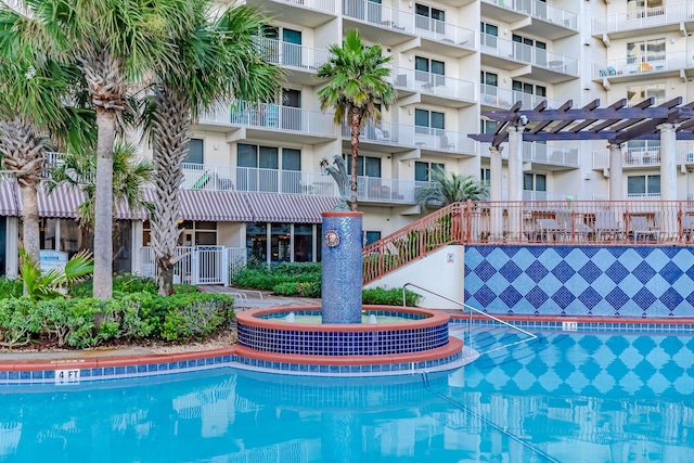 view of pool featuring a community hot tub and a pergola