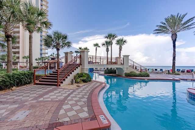 view of pool featuring a patio and a water view