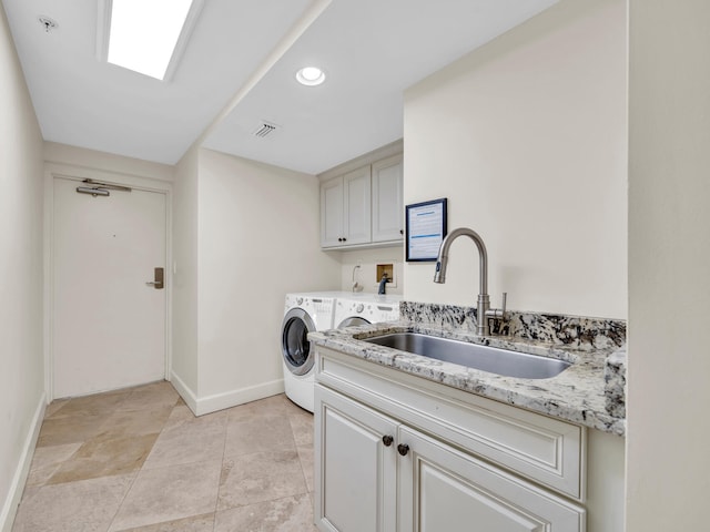 clothes washing area with separate washer and dryer, a sink, visible vents, baseboards, and cabinet space