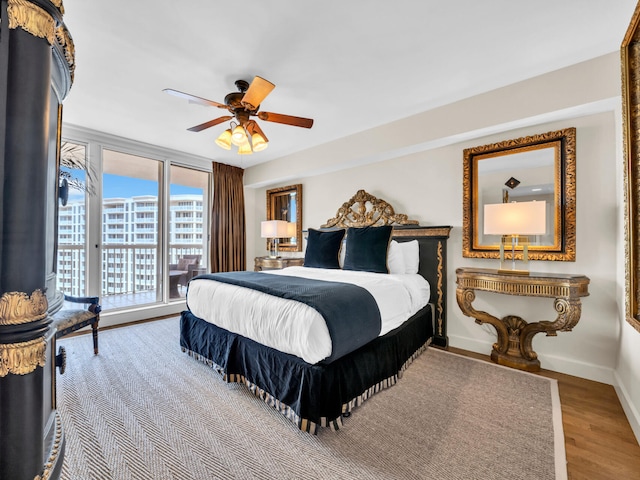 bedroom with wood finished floors, a ceiling fan, and baseboards