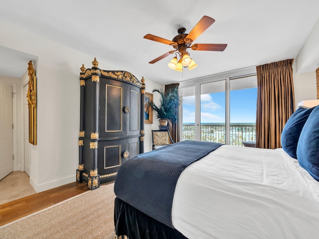 bedroom with access to outside, ceiling fan, baseboards, and wood finished floors