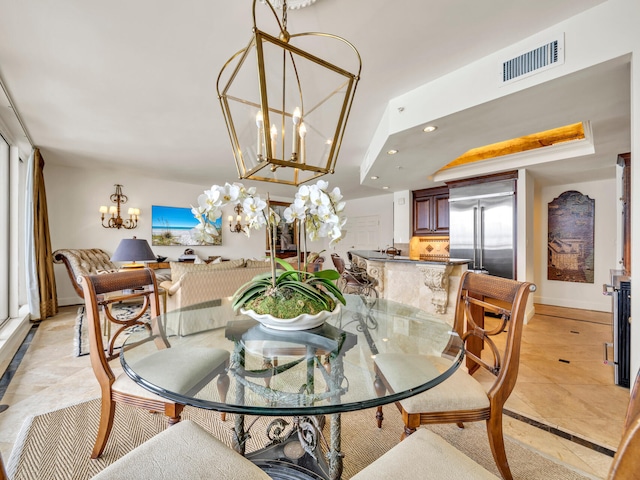 dining area featuring a notable chandelier, recessed lighting, a raised ceiling, visible vents, and baseboards