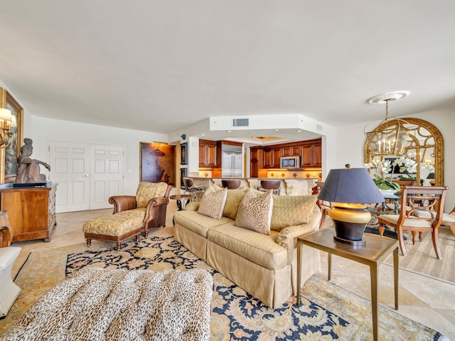 living area featuring visible vents and a notable chandelier