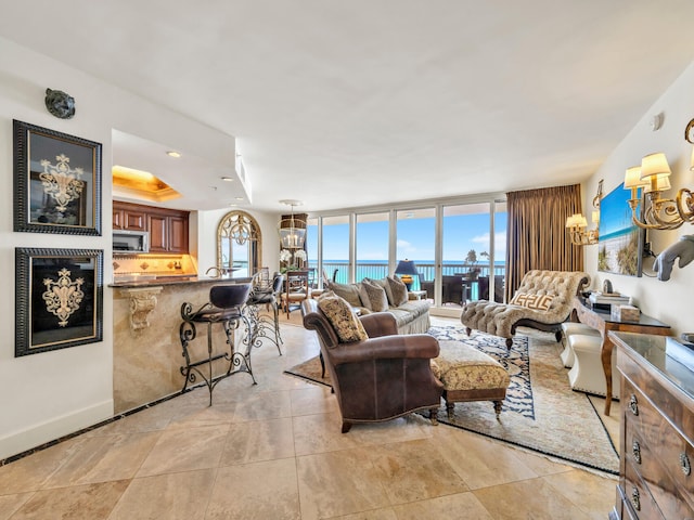 living room with a wealth of natural light, a water view, and an inviting chandelier