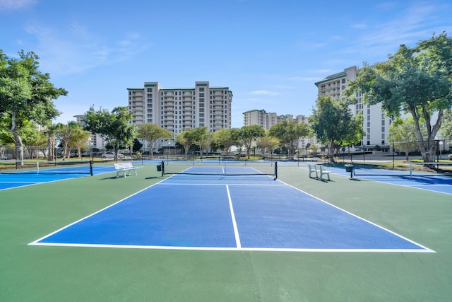 view of sport court featuring a view of city and fence