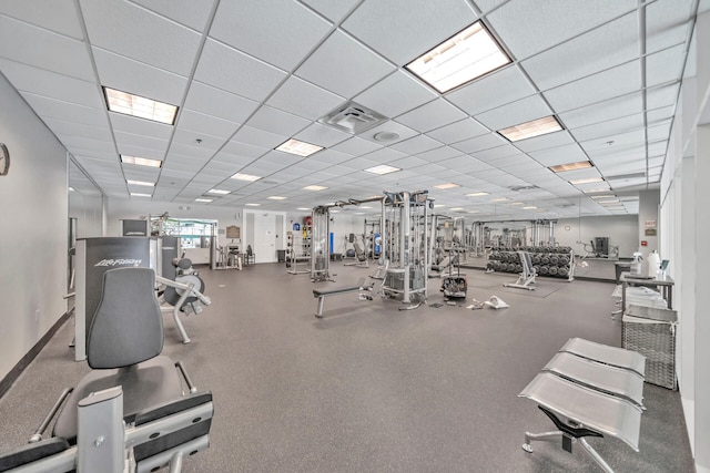 gym featuring baseboards, visible vents, and a drop ceiling