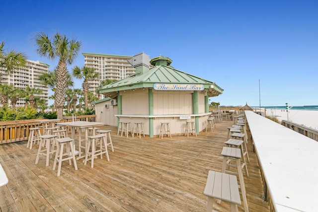 deck with a view of the beach, a water view, outdoor dry bar, and a gazebo