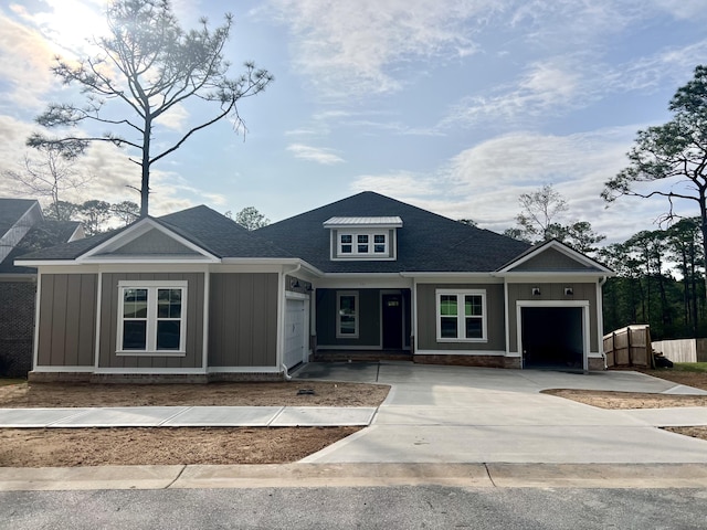 view of front of property featuring board and batten siding, driveway, a shingled roof, and a garage