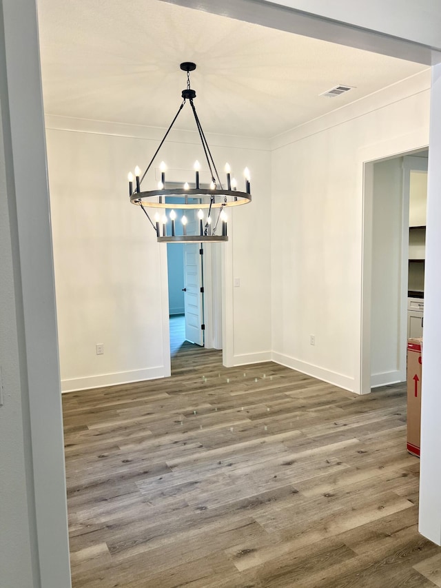 unfurnished dining area featuring baseboards, wood finished floors, and crown molding