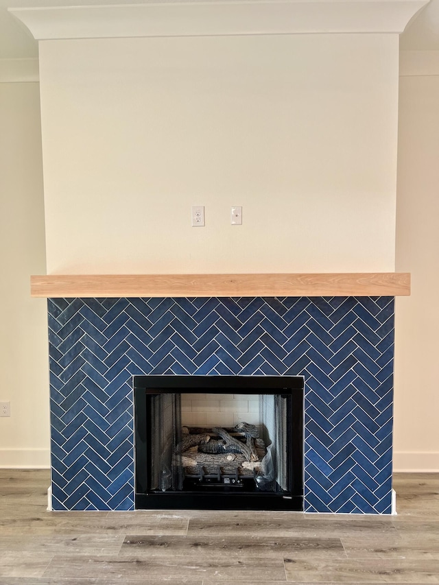 interior details with a fireplace, baseboards, and wood finished floors