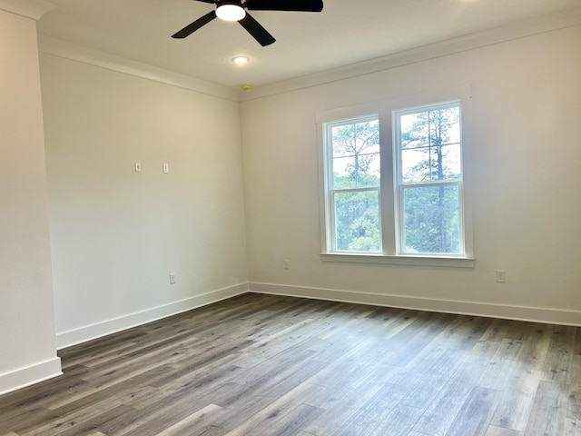 spare room with dark wood-style floors, baseboards, and ornamental molding