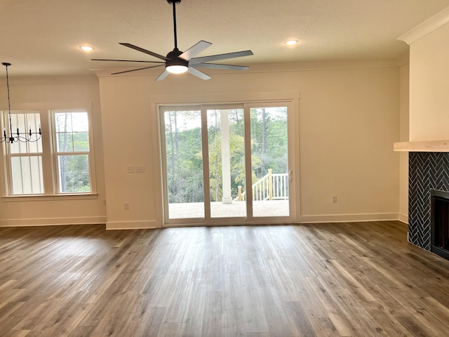 unfurnished living room with plenty of natural light, a fireplace, and crown molding