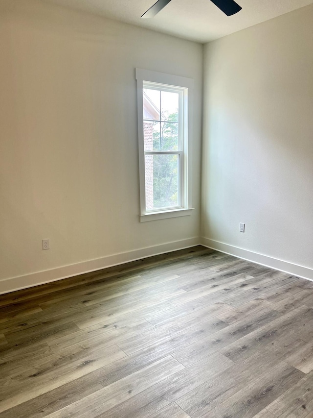 unfurnished room featuring ceiling fan, baseboards, and wood finished floors