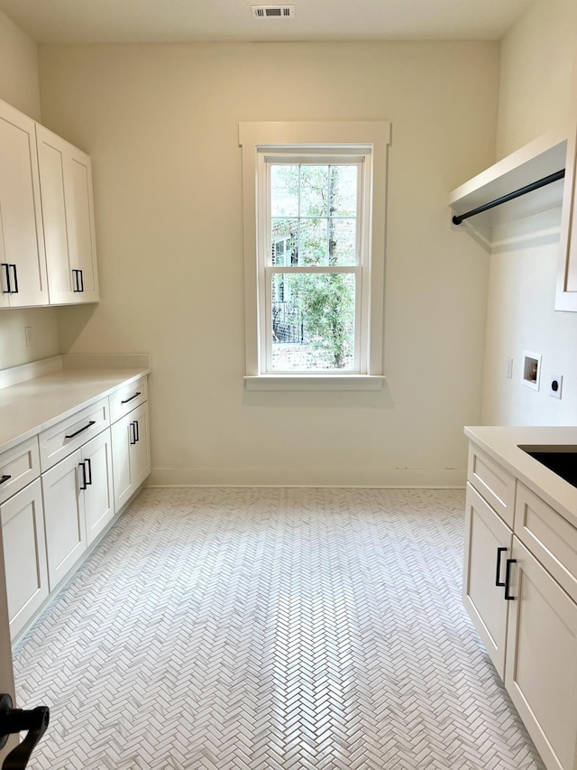 washroom with washer hookup, visible vents, cabinet space, and electric dryer hookup