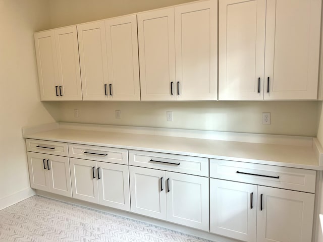 kitchen with white cabinets, baseboards, and light countertops