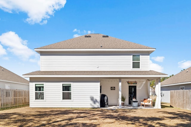 rear view of property with a yard and a patio area