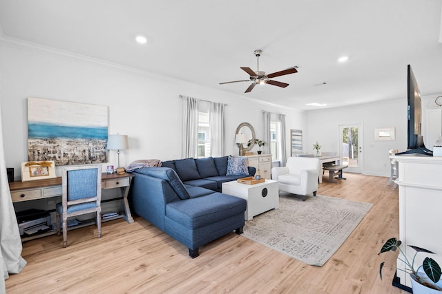 living room featuring crown molding, light hardwood / wood-style flooring, and ceiling fan