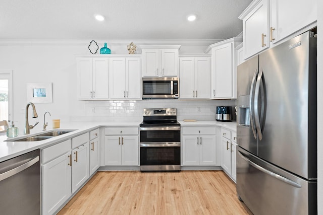 kitchen featuring sink, crown molding, appliances with stainless steel finishes, white cabinets, and backsplash