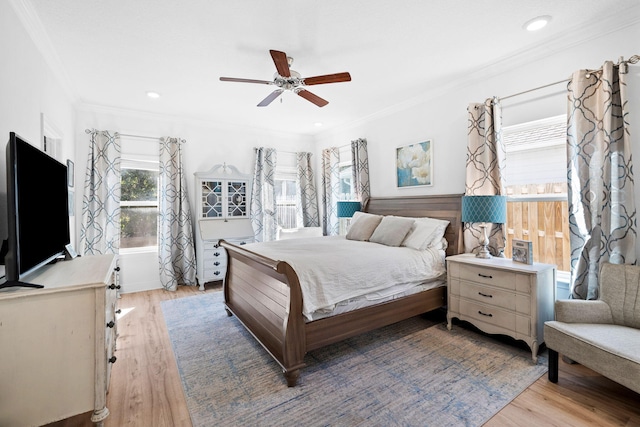 bedroom with ornamental molding, ceiling fan, and light wood-type flooring