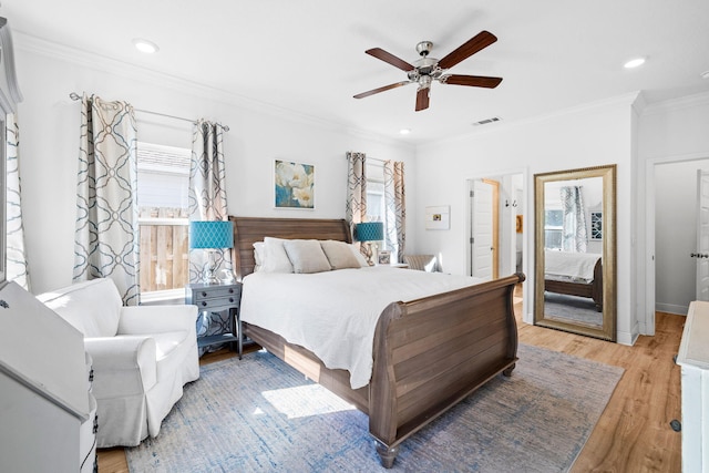 bedroom with multiple windows, crown molding, ceiling fan, and light hardwood / wood-style flooring